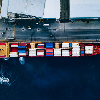 Aerial top view of industrial cargo container ship in terminal in Italy