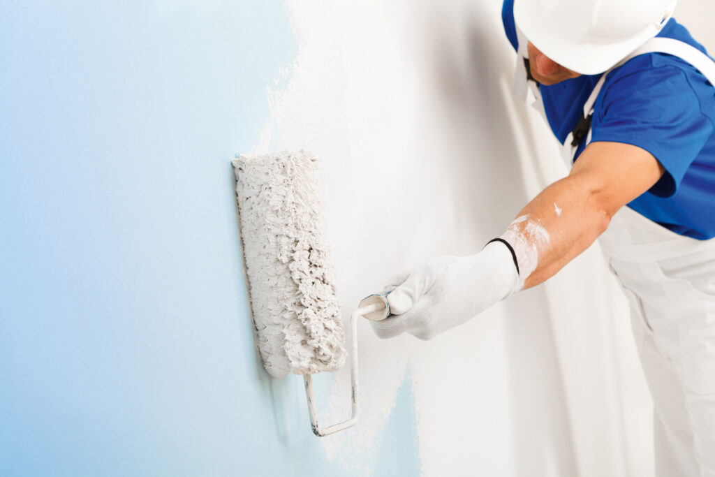 painter painting a wall with paint roller