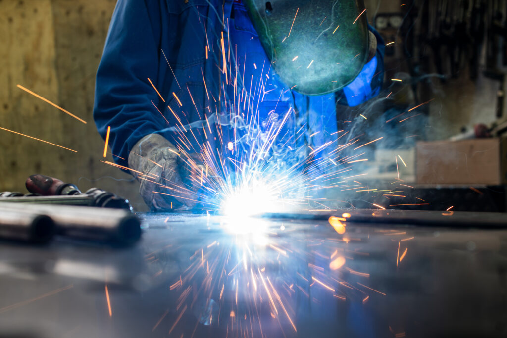 Welder in his workshop welding metal