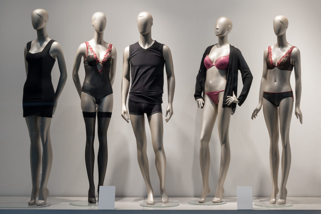 Modern and luxury shop of underwear. Full-length male and female mannequins in nderwear. Lingerie on plastic dolls in store window display.
