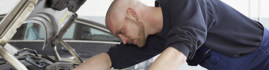 Mechanic looking under hood of car