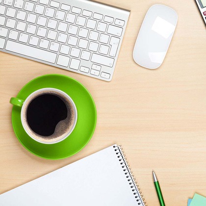 Office table with coffee cup, computer and flower